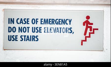 Sicherheitsschild für den Notfall an der Gebäudewand lesen im Notfall keine Aufzüge verwenden Treppen mit grafischem Symbol verwenden. Stockfoto