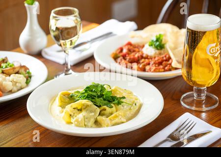 Köstliches Pasta-Gericht mit Wein und Bier in gemütlicher Atmosphäre Stockfoto