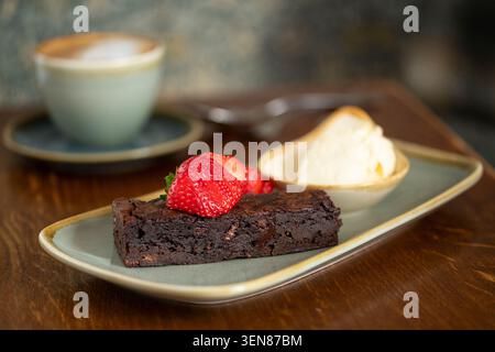 Köstlicher Chocolate Brownie, ergänzt durch frische Erdbeeren und cremiges Eis Stockfoto