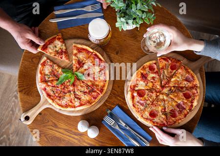 Genießen Sie köstliche Pizza mit Freunden in einem gemütlichen Restaurant im Herzen der Stadt Stockfoto