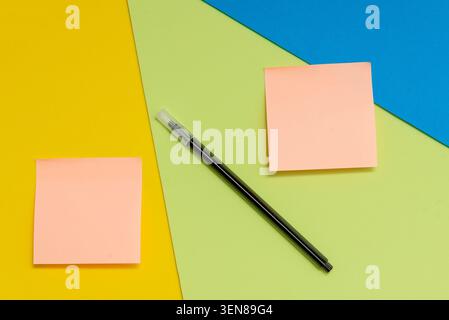 Schwarzer Filzstift und farbige Aufkleber mit Kopierraum für Text auf gelbem grünem und blauem Hintergrund Stockfoto