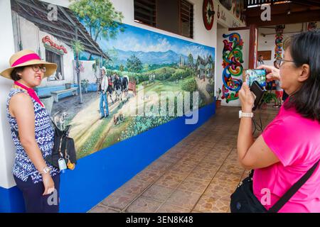 Sarchi Costa Rica, Fabrica de Carretas Eloy Alfaro, Alfaro Castro Hermanos Carretas, handgefertigte Ochsenkarren, Werkstattführung, asiatische Touristen, Frau Stockfoto