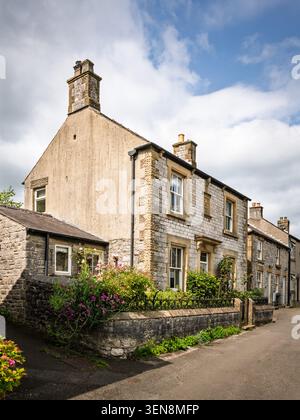 Vertikale Portraitansicht historischer Steinhäuser mit einem kleinen eingezäunten Vorgarten entlang der Sherwood Road in Tideswell, Peak District, Derbyshire, England Stockfoto