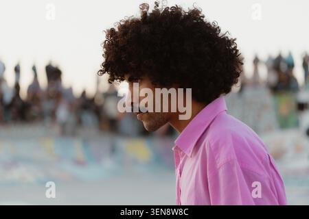 Nahaufnahme des Seitenprofils eines jungen Mannes mit lockigem Haar und Schnurrbart. Stockfoto