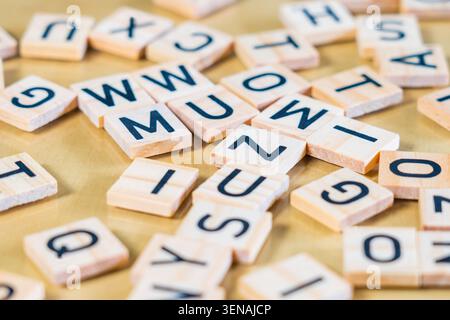 Sammlung von Holzfliesen, auf denen Buchstaben mit schmaler Schärfentiefe gedruckt sind, wodurch Unschärfen am oberen und unteren Rand des Bildes entstehen Stockfoto