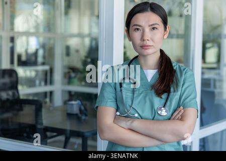 Süße junge Ärztin im Laborkittel und mit Stethoskop um den Hals Stockfoto