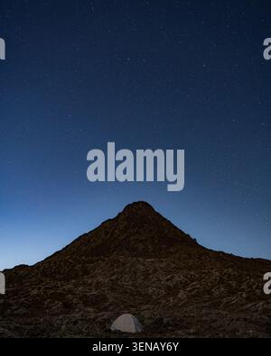 Nächtlicher Blick auf den Piquinho Gipfel mit einem beleuchteten Campingzelt im Vordergrund unter einem Sternenhimmel, Mount Pico, Azoren, Portugal Stockfoto