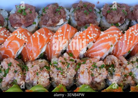 Sushi-Brötchen mit Lachs, Thunfisch, Gurke, Frischkäse und Wasabi Stockfoto