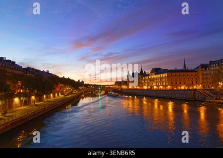 Conciergerie Gebäude entlang des Flusses Seine entfernt und das Zentrum von Paris unter einer frühen Sonnenaufgang leuchtet. Es wurde sukzessive King's Palace die Pri Stockfoto