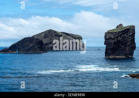 Dramatische Meeresstapel und übereinander angelegte Basaltklippen erheben sich vom Atlantik mit tiefblauem Wasser und wolkenbewölktem Himmel und erinnern an die raue, abgelegene Küstenlandschaft. São M Stockfoto