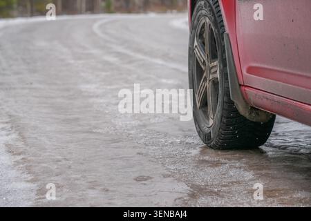 Autoreifen auf vereisten Winterstraßen mit gefährlichen Fahrbedingungen und rutschigem Untergrund Stockfoto