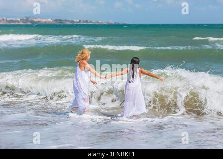 Glückliche Reife Frauen, die Meereswellen am Strand genießen Stockfoto