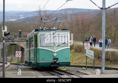 Königswinter, Deutschland - 22. Februar 25: Grüne Straßenbahn der Drachenfelsbahn, die auf Bergbahngleisen bei Schloss Drachenburg in Königswinter ankommt, Stockfoto