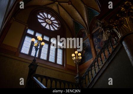 Königswinter, Deutschland - 22. Februar 25: Treppenaufgang mit rosa Buntglasfenster und bemalten Wänden im Schloss Drachenburg in Königswinter, GE Stockfoto