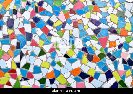 Nahaufnahme der Wand aus unregelmäßigen kleinen bunten Mosaiksteinen, unebene strukturierte dekorative Oberfläche mit lebendigem Muster Stockfoto