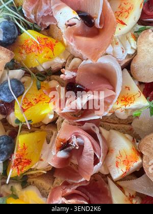Buntes Fingerfood-Sortiment mit offenen Sandwiches, Fleischgerichten, Meeresfrüchten und frischem Gemüse für Buffet- oder Luxusveranstaltungen Stockfoto