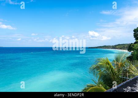 Klares türkisfarbenes Wasser trifft auf weißen Sand und üppiges Grün am Bira Beach in Sulawesi, Indonesien, unter einem hellen tropischen Himmel Stockfoto