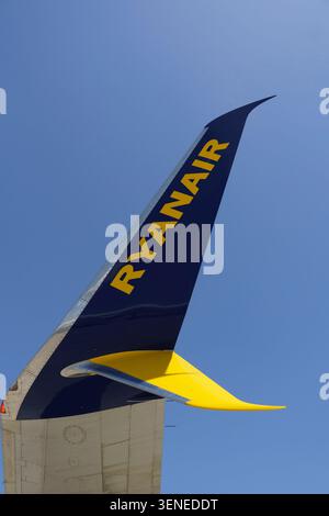 Nahaufnahme eines blau-gelben Ryanair Winglets mit dem Firmenlogo vor einem klaren blauen Himmel Stockfoto