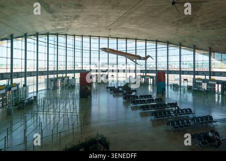 Geräumiges Interieur des modernen Flughafenterminals Valencia in Spanien mit einem hängenden Modellflugzeug und einer großen Glasfassade Stockfoto