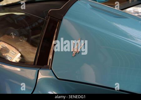 Nahaufnahme des verchromten Trident-Emblems an einem modernen hellblauen Maserati-Sportwagen-Cabrio Stockfoto