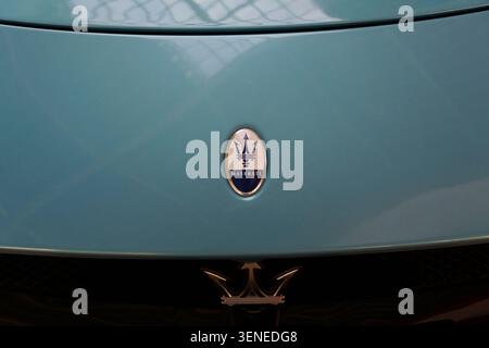 Nahaufnahme des Maserati Trident Emblems auf der vorderen Motorhaube eines blauen Luxussportwagens Stockfoto