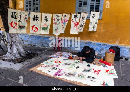 Ein vietnamesischer Schriftsteller/Künstler, der traditionelle Kalligraphie verwendet, indem er einen spitzen Stift verwendet, der mit schwarzer indischer Tinte beschichtet ist und verschiedene Strichbreiten durchzieht Stockfoto