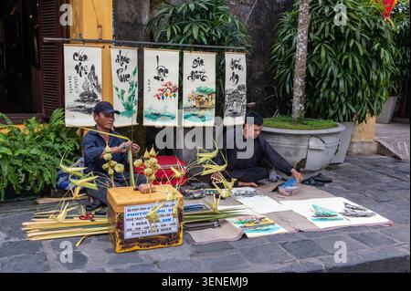 Ein Künstler an seinem Stand mit seinen Kunstwerken, die in der Tran Phu Straße in Hoi, einer antiken Stadt, in der Provinz Quang Nam, Zentralvietnam, verkauft werden. Hoi an ist ein UNESCO-Arbeitsamt Stockfoto