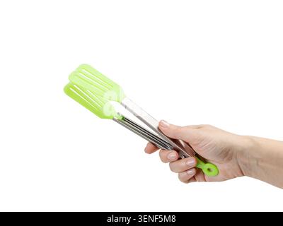 Die Hand einer Frau, die eine Küchenzange auf weißem Hintergrund hält. Stockfoto