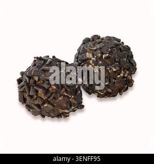 Handgefertigte Trüffel aus dunkler Schokolade, die mit knusprigen Schokoladenstückchen auf weißem Hintergrund für Gourmet-Süßwaren überzogen sind. Stockfoto