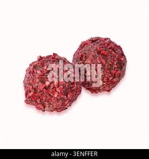 Handgefertigte Himbeer-Schokoladentrüffel, beschichtet mit gefriergetrockneten Himbeerstücken, isoliert auf weißem Hintergrund für Gourmet-Dessert-Konzept. Stockfoto