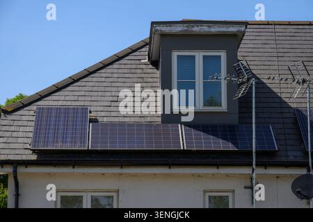 Wohnhausdach mit Solarpaneelen für die Erzeugung erneuerbarer Energien an einem hellen sonnigen Tag in Großbritannien. Stockfoto