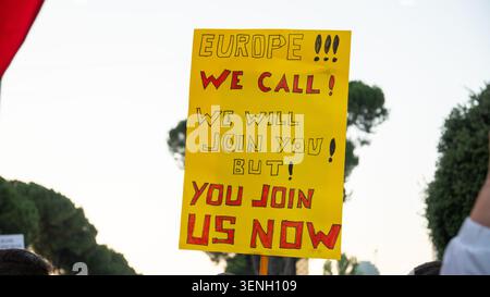 Ein Demonstrant hält ein gelbes Plakat, das Europa um Unterstützung während einer regierungsfeindlichen Demonstration in Tirana aufruft. Stockfoto