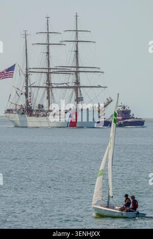Charleston, Usa. Juni 2026. Ein J22-Segelboot fährt als Motor der U.S. Coast Guard Cutter Eagle in den Hafen von Charleston, wo es im Rahmen des Cadet Summer Trainings am 11. Juni 2026 in Charleston, South Carolina, dreitägige Hafenbesuche gibt. Die Eagle ist eine 295 Meter lange Barke mit drei Masten, die als Trainingsschiff für die US-Küstenwache dient. Quelle: Richard Ellis/Richard Ellis/Alamy Live News Stockfoto