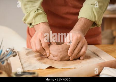 Töpferhände Formen Ton auf Holztisch, basteln Töpferei in einer Werkstatt, kreative Kunst und Hobby Stockfoto