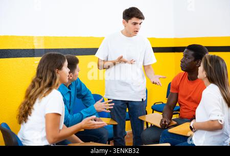Gruppe junger Studenten, die an der Universität mit einem männlichen Tutor studieren Stockfoto