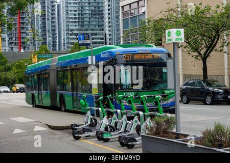 Vancouver, Kanada - 8. Juni 2026: Ein TransLink RapidBus 257 nach Horseshoe Bay fährt neben einer geparkten Reihe von Lime E-Scootern auf Dunsmuir bei Cambie Down Stockfoto