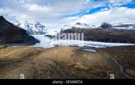 Svinafellsjokull Gletscher und Berge unter bewölktem Himmel in Island im späten Frühling das Gelände in Island, umgeben von schneebedeckten Bergen Stockfoto