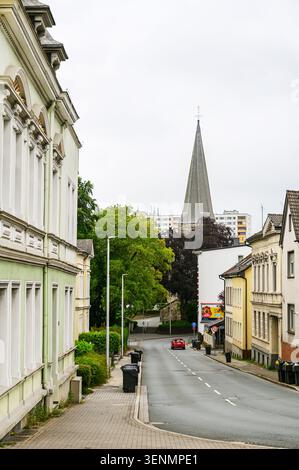 Iserlohn, Deutschland - 05. Juni 2026: Urbane Straßenszene mit historischer Architektur, Kirchturm und Wohnhäusern. Stockfoto