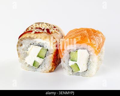 Nahaufnahme von zwei frischen japanischen Uamaki-Sushi-Brötchen. Einer mit Orangenlachs, der andere mit Aal-Sesamsamen. Gefüllt mit Frischkäsegurke Stockfoto