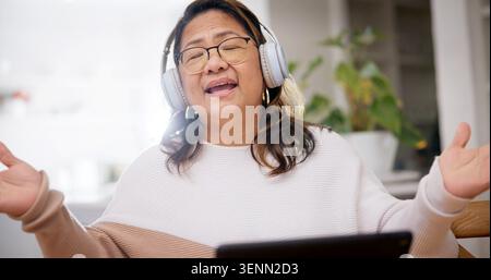 Singen, Kopfhörer oder Frau zu Hause mit Streaming, Musikverbindung oder Musik-Playlist hören. Online-, Techniker- oder Senior-Person mit geschlossenen Augen Stockfoto