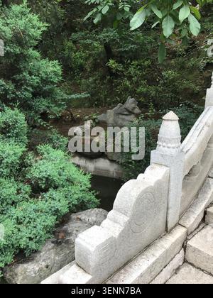 PEKING, CHINA - 10. JULI 2018: Traditionelle gemeißelte Steinbrückengeländer und ein Steingarten mit einer roten Inschrift an einem Bach in der Chinesischen Mauer Stockfoto