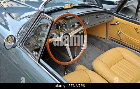Udine, Italien. April 2024. Lenkrad aus Holz, Armaturenbrett und braunes Lederinterieur von Lancia Aurelia, einem luxuriösen Cabriolet aus den 50er Jahren Stockfoto