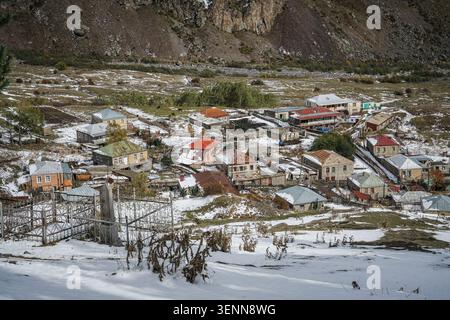 Ein Blick aus der Vogelperspektive zeigt das malerische Dorf Stepantsminda, Georgia, mit seinen vielen Häusern mit farbenfrohen Dächern, die mit Schnee im frühen Winter bedeckt sind. Stockfoto
