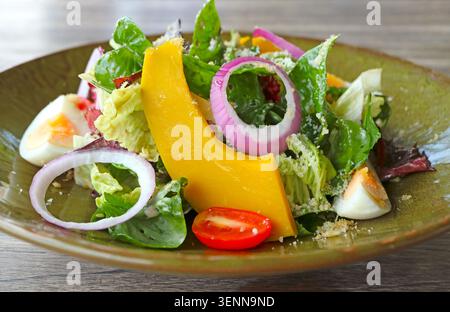 Gesunder vegetarischer Salat mit gemischtem Gemüse, hart gekochtem Ei und geriebenem Käsebelag Stockfoto