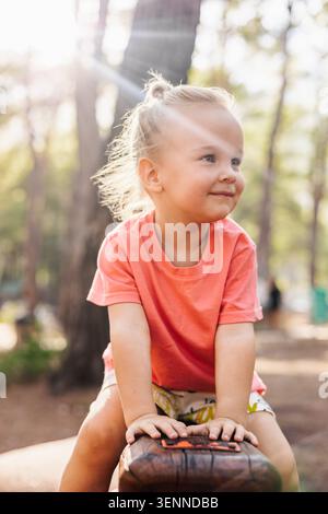 Niedliches Kleinkind mit blonden Haaren, das draußen lächelt Stockfoto