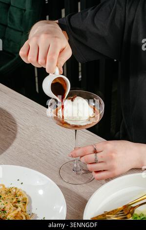 Ein Mann, der Espresso über eine Schaufel Eis gießt Stockfoto