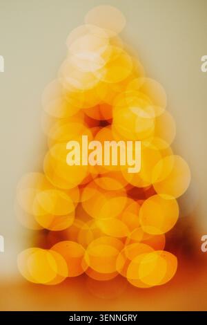 Goldene Bokeh-Lichter bilden eine abstrakte Baumform Stockfoto