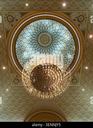 Ein Blick nach oben auf einen Kristalllüster, der an der aufwendig verzierten geometrischen Kuppel hängt, Qasr Al Watan Presidential Palace, Abu Dhabi, VAE Stockfoto
