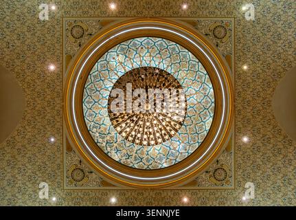 Ein Blick nach oben auf einen Kristalllüster, der an der aufwendig verzierten geometrischen Kuppel hängt, Qasr Al Watan Presidential Palace, Abu Dhabi, VAE Stockfoto