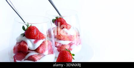 Erdbeer-Tiramisu. Authentisches italienisches Sommerdessert mit Schichten Sahne, frischen Erdbeeren und Keksen in Gläsern auf weißem Hintergrund. Stockfoto
